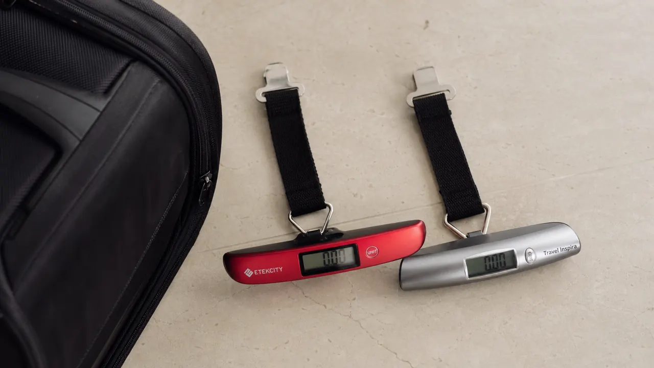 Etekcity digital luggage scale hanging from a suitcase handle with a clear weight reading on the display